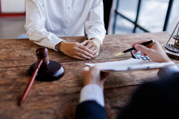 Two lawyers Consultation and conference discussing legal matters at a desk with a gavel, scales of justice law symbolizing law and justice, justice and lawyer Business partnership meeting concept. 
