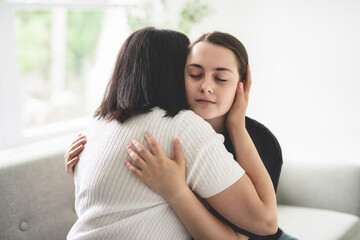 mother comforting depressed sad teen girl, hugging daughter with love