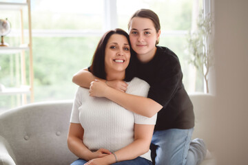 mother with teen girl, having great time on sofa