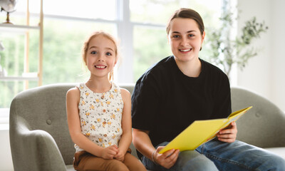 babysitter teen read book with cute 5 years child girl