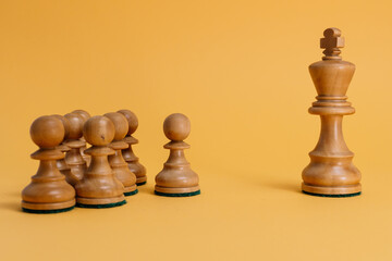 Business leadership and team concept with chess king and pawns.  Chess king facing team of pawns on...