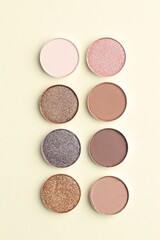 Beautiful eyeshadow refill pans on beige background, flat lay