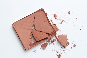 Broken eyeshadow refill pan on white background, top view