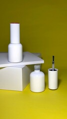 Nail polish, white nail polish bottle with brush on yellow background, manicure concept
