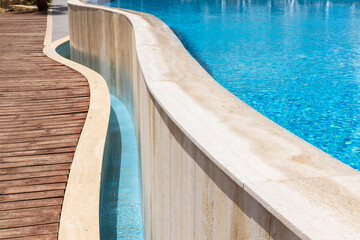 Curved Wall Of A Swimming Pool With Wooden Deck