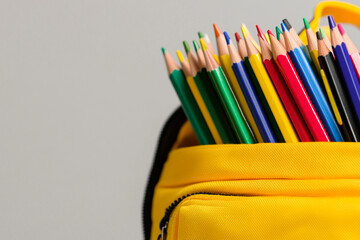 Fototapeta premium Brightly colored pencils and school supplies organized in a backpack
