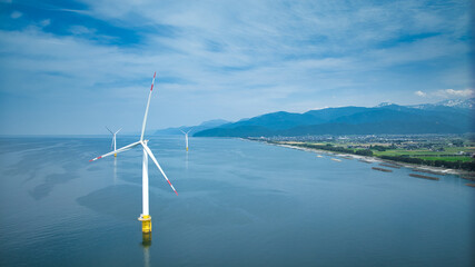梅雨間際で湿度の高い日本の沿岸部と離岸堤や洋上風力発電風車などの様子