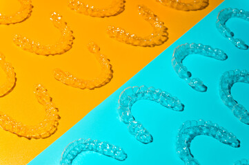 Braces, invisible aligners. cyan and orange background. Prevention and treatment of gums and teeth, modern jaw straightening