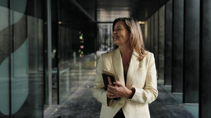 Confident business woman walking in a modern office corridor. Portrait of female executive - Powered by Adobe