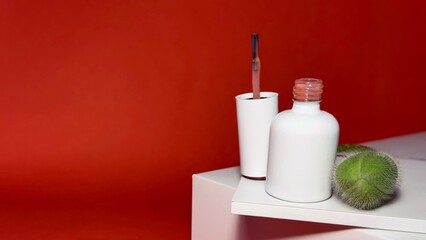 Nail polish on red background, spa still life