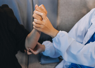 Orthopaedic doctor doing physical examination patient with wrist pain at the clinic. Physical therapist checks the patient wrist by pressing the wrist bone.