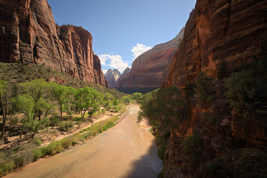 Scenic view of a river flowing through a red rock canyon under a blue sky