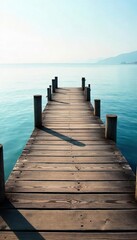 Rustic wooden pier stretches out over calm, blue water towards a hazy horizon, bathed in soft sunlight Perfect for travel, vacation, or coastal themed projects , wood, serene