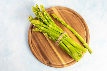 Green Asparagus on a wooden plate