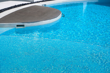 Empty swimming pool with sunbed and white modren resort hotel for vacation leisure and white sand,resort neary sea and beach in summer.