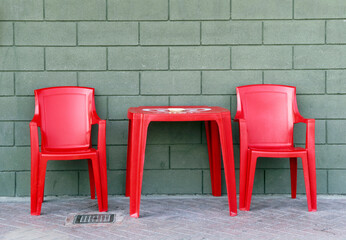 red plastic chairs and table outside a bar