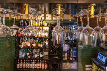 Hanging Glasses in a Bar with Bottles of