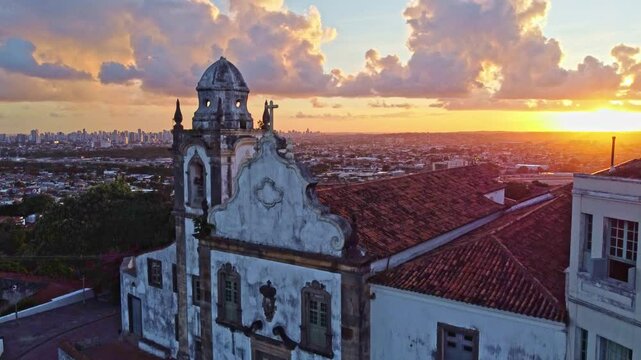 At sunset in Brazil, an aerial view of the historic architecture of Olinda in Pernambuco, Brazil with its 17th century buildings on cobblestone streets. 