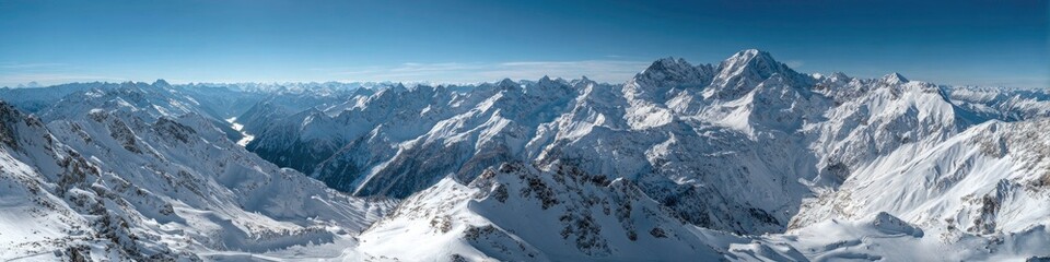 Fototapeta premium Panoramic View of Snow Covered Mountain Range Under a Clear Blue Sky