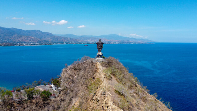 Scenic panoramic aerial view of Cristo Rei landmark statue overlooking blue ocean in capital city Dili, Timor-Leste, Southeast Asia