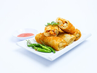 Indonesian risoles filled with vegetables, served with fresh green chilies on a white plate. Crispy breadcrumb coating on white background