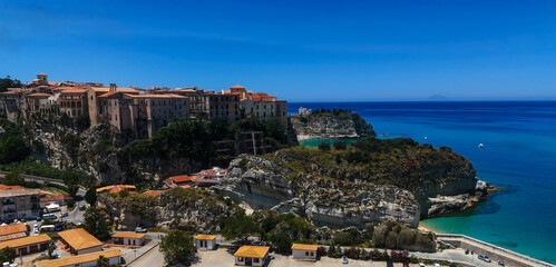 Fototapeta premium Aerial view of Tropea, a charming town perched on a cliff overlooking the turquoise waters of the Tyrrhenian Sea, Calabria, Southern Italy