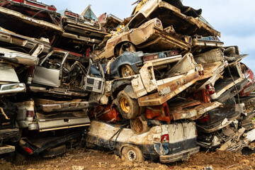 A stack of wrecked cars in a junk yard