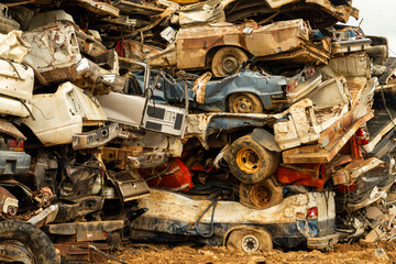 A stack of wrecked cars in a junk yard