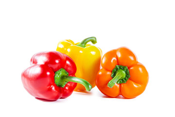 Fresh juicy shiny red, yellow and orange bell peppers. Isolated on white.