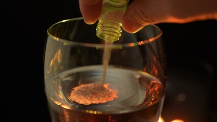 Club cocktail in the disco party get drugged. Putting drugs in drink at the bar. Strange unknown medicine powder falling down in glass with adult drink. Drink spiking.