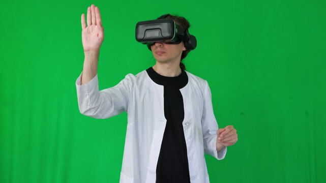  A mid-shot captures an immersive and futuristic mood as a person in a white lab coat and VR headset makes hand gestures, suggesting virtual reality interaction or gaming, green screen background