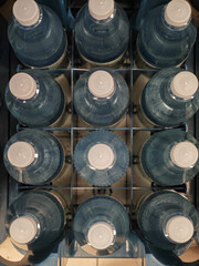 Clear bottled water arranged in a neat grid on a shelf in a store during daytime