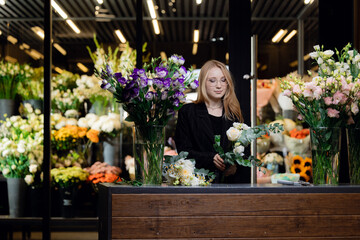 Small business owner, young woman florist making bouquet working at flower shop