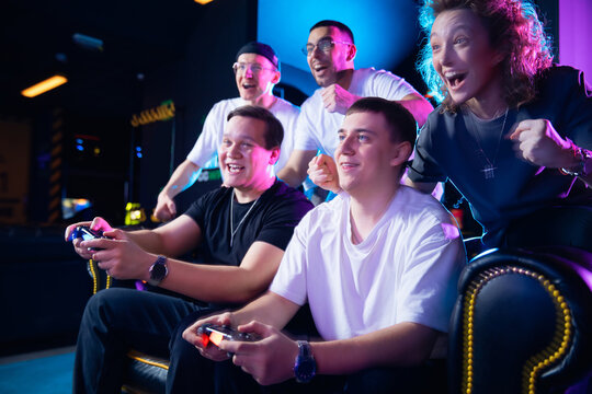 Group of diverse young adults enjoying esports gaming together in exciting atmosphere