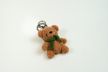 taking a cute teddy bear keychain in isolated white background
