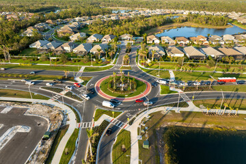 Aerial view of roundabout intersection on American road with moving traffic cars. Urban circular transportation crossroads