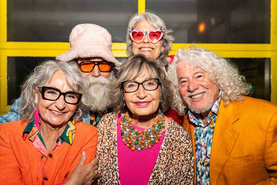 Group of happy senior friends with fancy clothing having party in the night