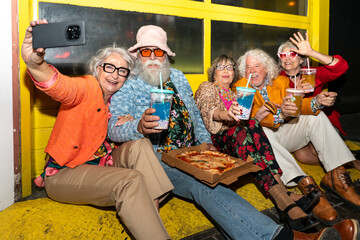 Group of happy senior friends with fancy clothing having party in the night
