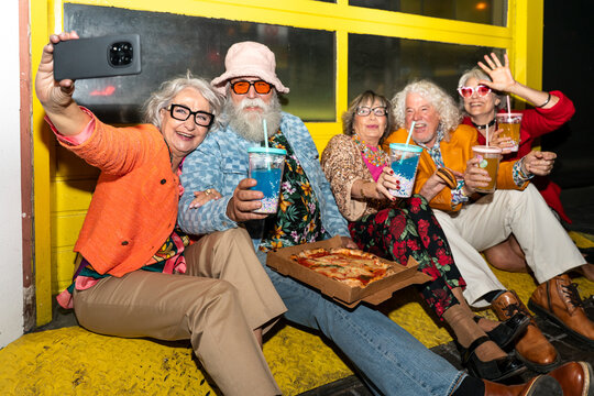 Group of happy senior friends with fancy clothing having party in the night