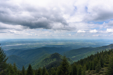 top view from mountain ladder landscape with clouds in summer carpathians romania with lights below clouds and green forests
