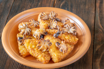 Golden Potato Rosti With Baby Octopuses Served On Rustic Wooden Table Plate