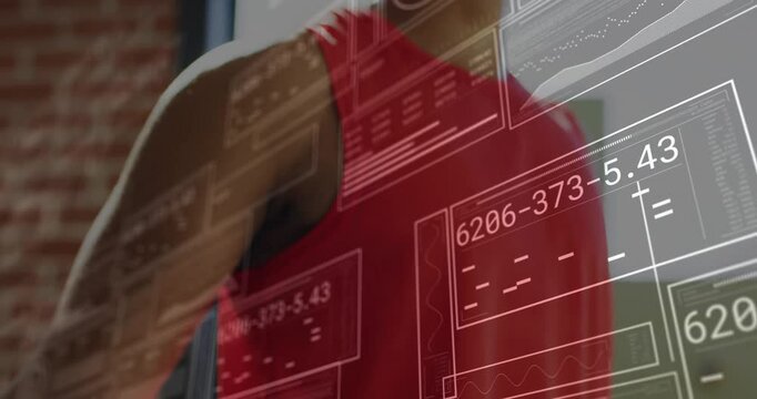 Fitness enthusiast stretching and punching in loft, showing data panels around smartwatch tracking - Powered by Adobe