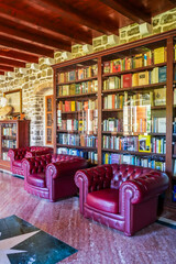  Library Interior in the Citadel, Budva, Montenegro — Bookshelves and Burgundy Chairs