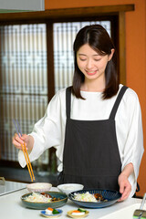 料理を箸で取り分ける姿が印象的な女性の穏やかな日常