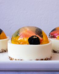 Postre de yogur con gelatina de frutas en bandeja de cerámica blanca y fondo blanco