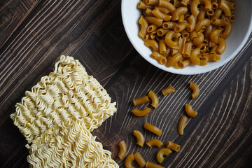 raw noodles and elbow macaroni pasta on a table wooden