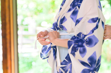 浴衣の帯を結ぶ女性の細やかな所作が映す和の美
