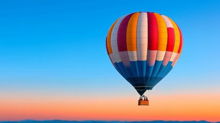 Naklejka premium Colorful hot air balloon soaring in clear blue sky during sunset