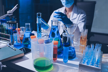 Scientist pipetting medical samples into microplate in laboratory