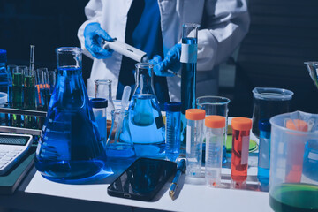 Scientist pipetting medical samples into microplate in laboratory